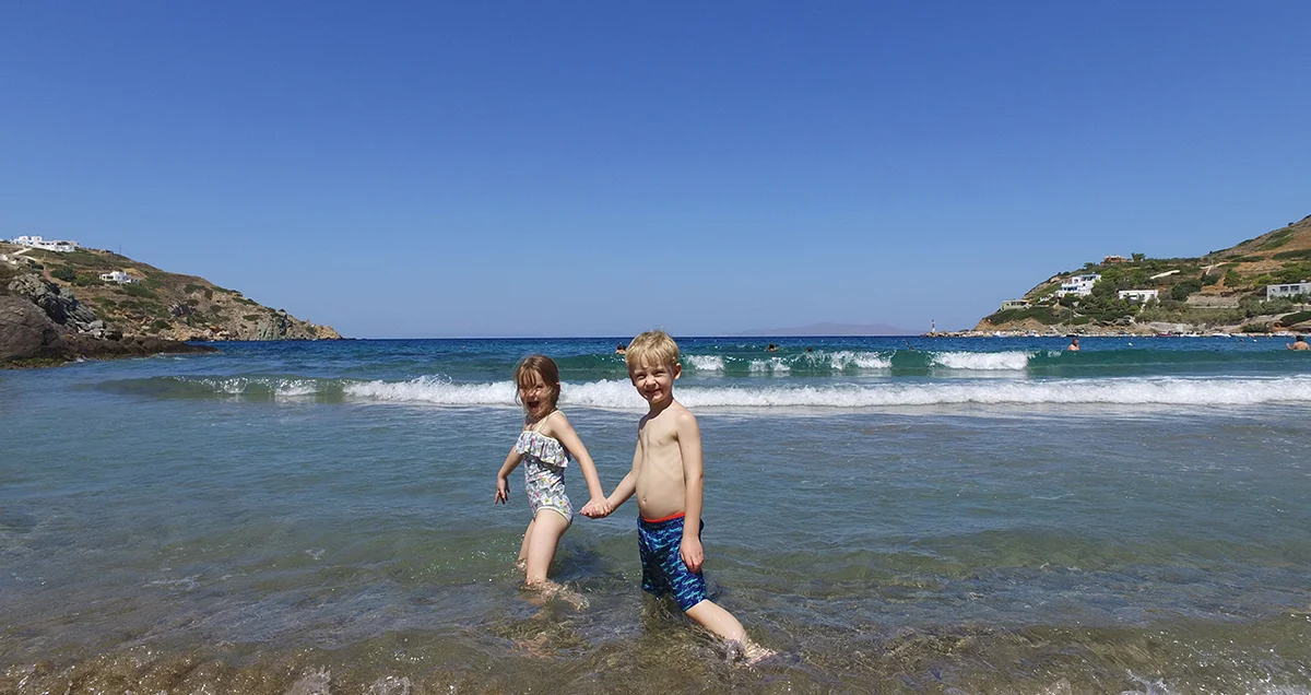 Zwei Kinder stehen im flachen Wasser am Strand