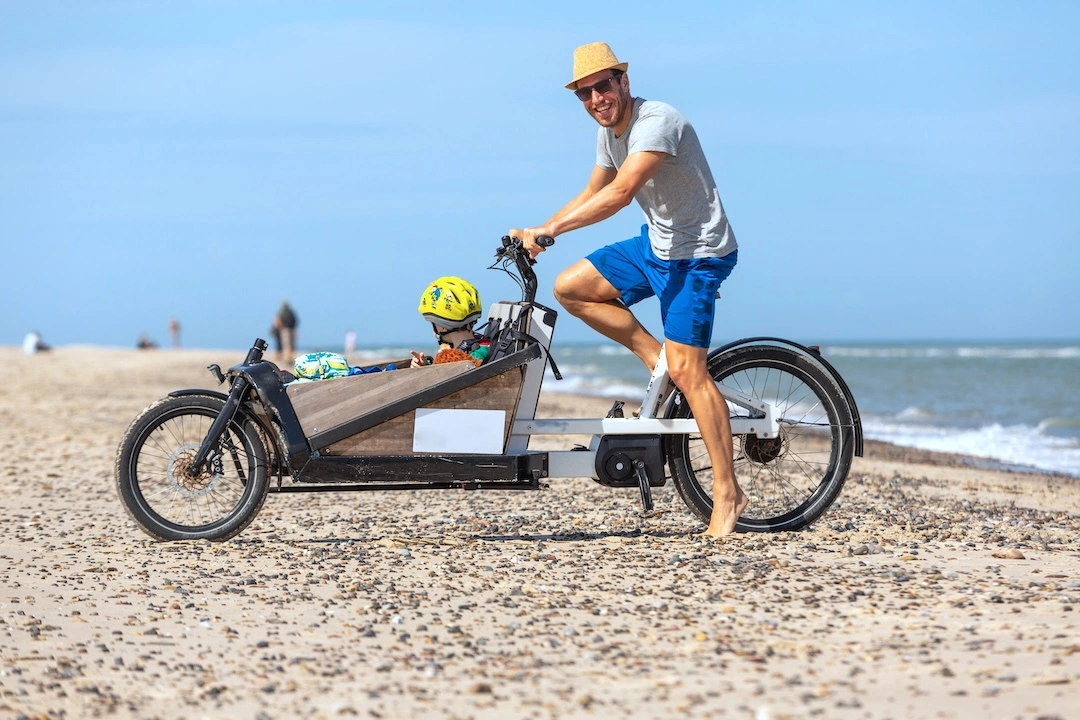 Mann mit Kind auf Lastenfahrrad Scharbeutz Strand