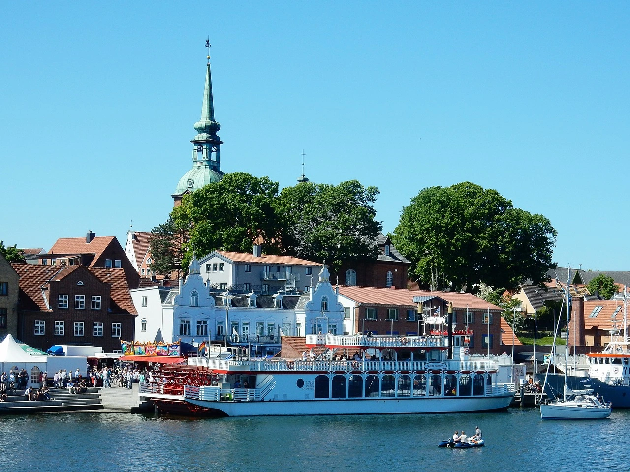 Dampfschiff im Kappelner Hafen vor Gebäuden und Promenade