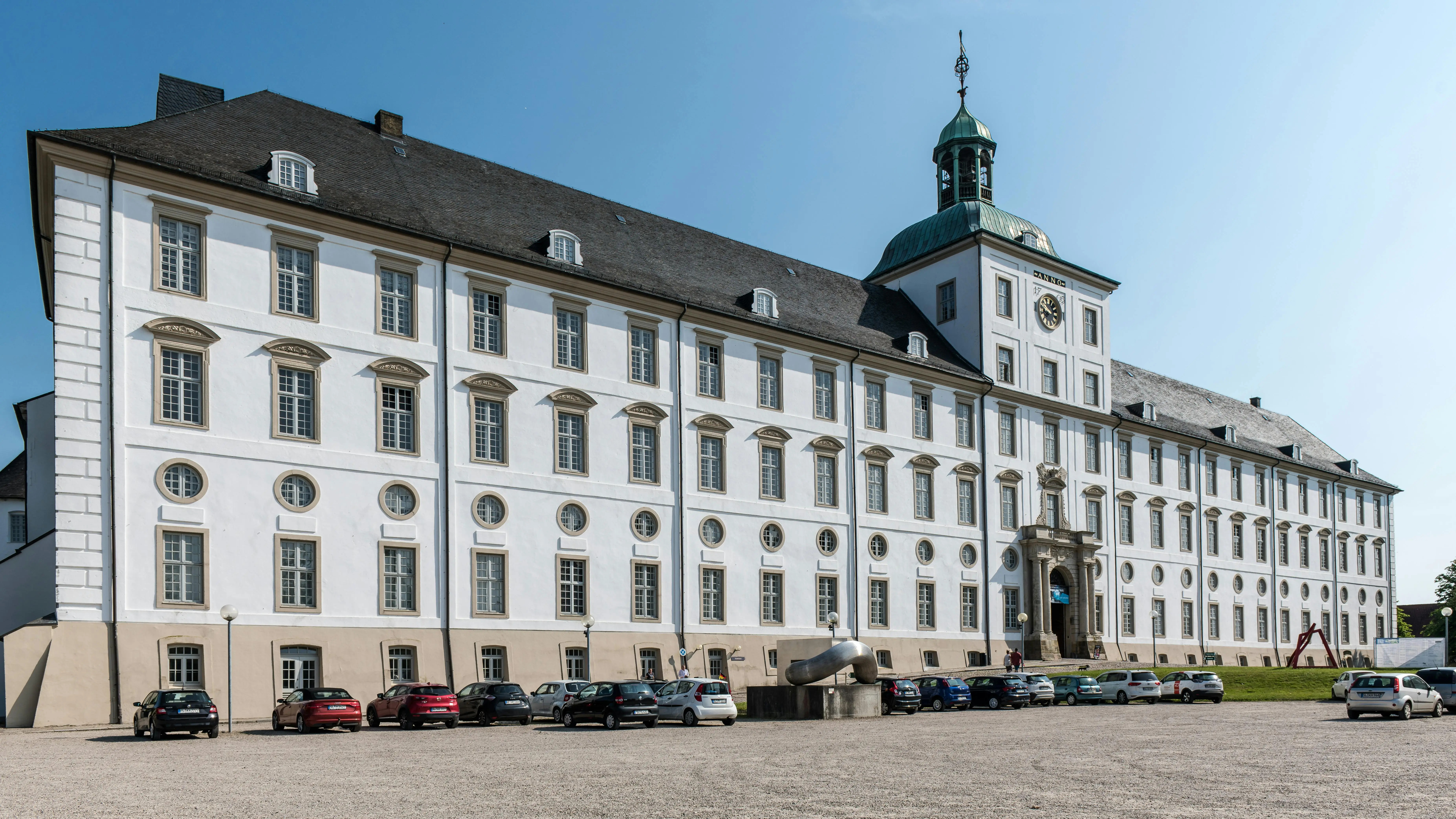 Autos parken vor Schloss Gottorf Hauptgebäude bei Sonnenschein