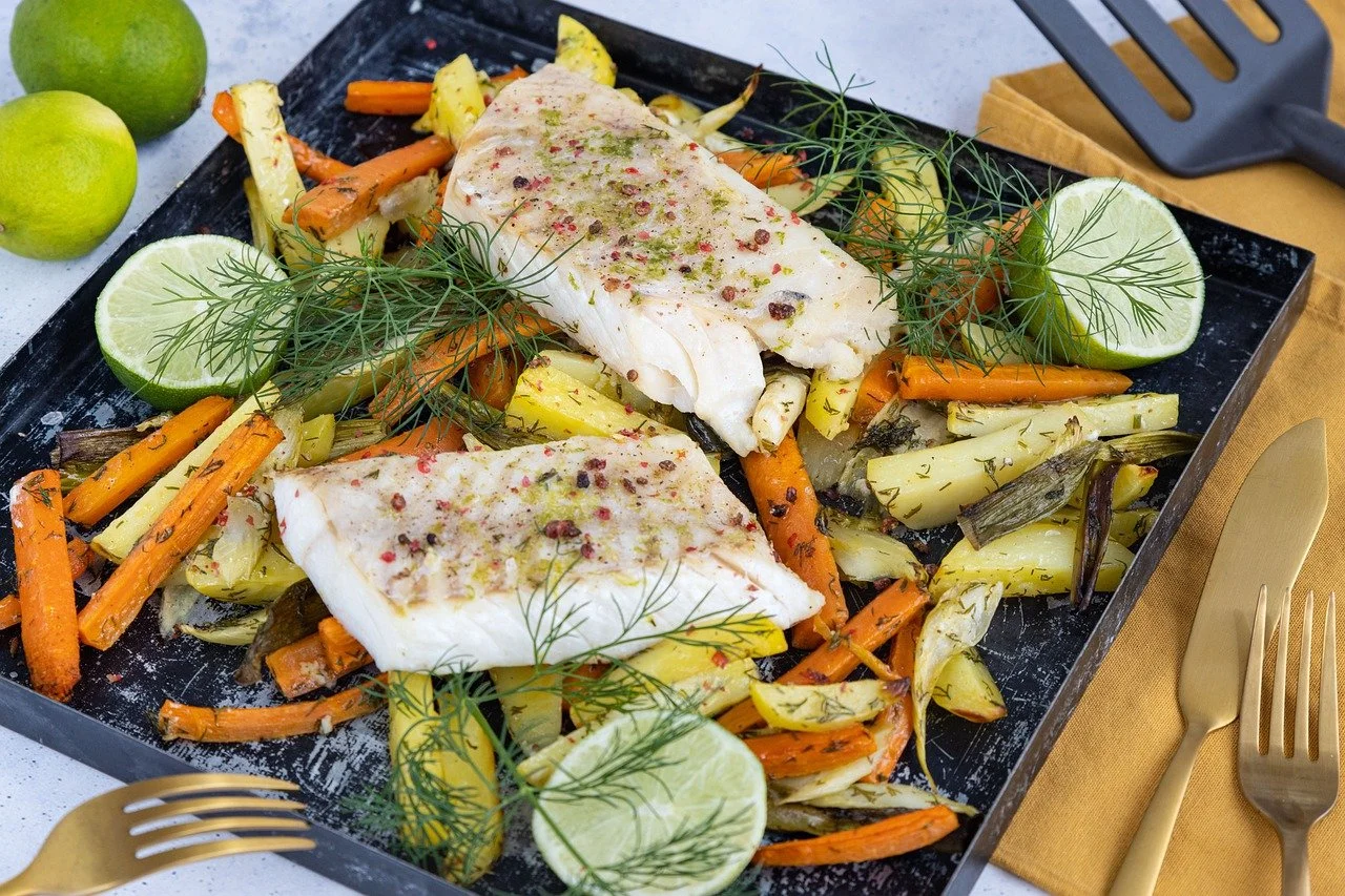 Teller mit Fischfilet, gebratenem Gemüse und Kräutern