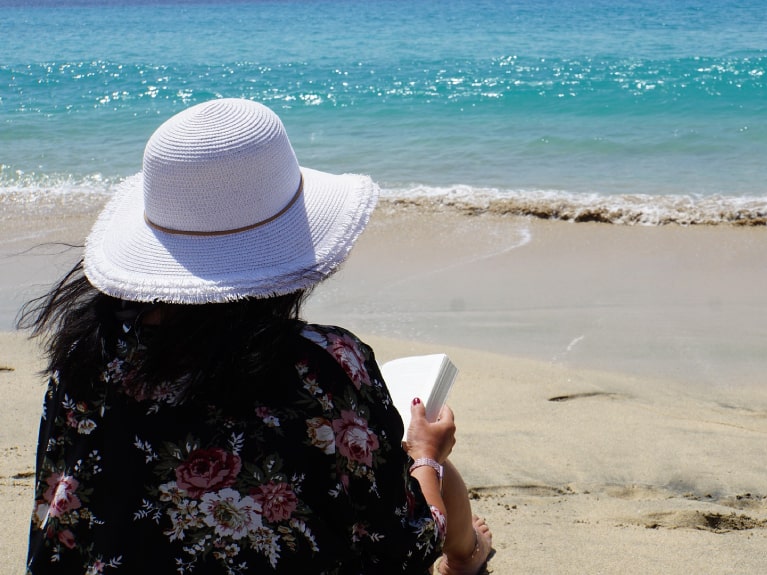Frau liest am Strand
