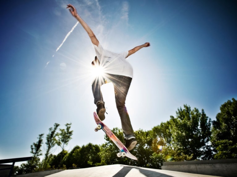 Kind springt mit Skateboard