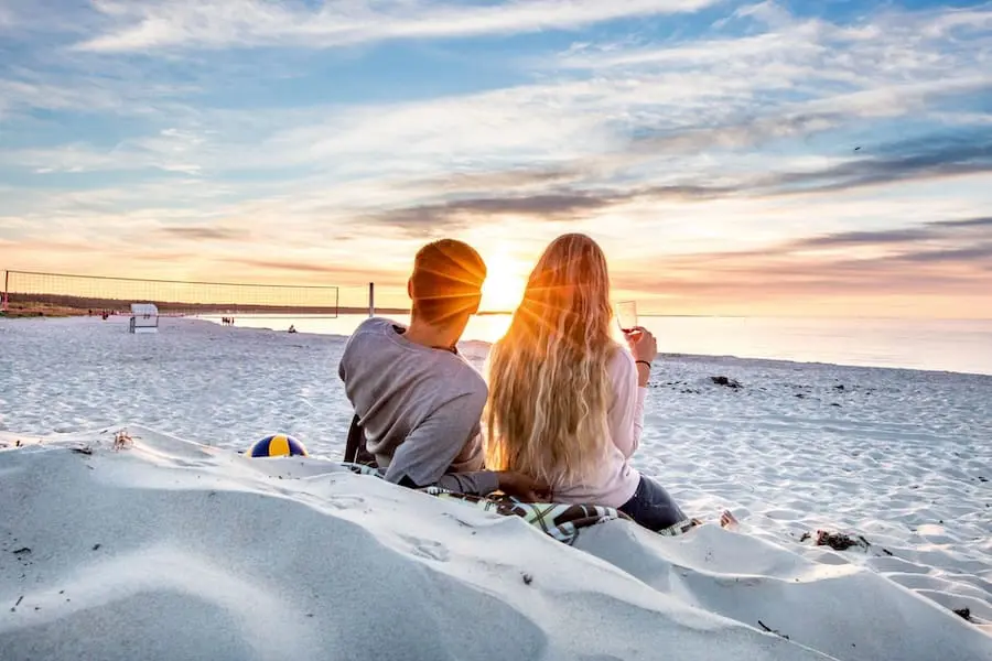 Paar sitzt am Strand und genießt den Ausblick auf das Wasser