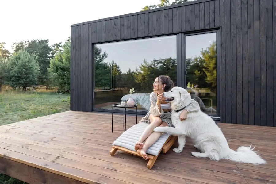 Frau und Hund genießen den Urlaub auf der Terrasse ihrer Ferienunterkunft