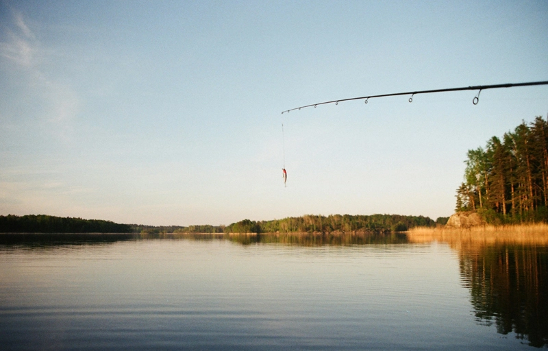 Angel mit hängendem Fisch an einem See