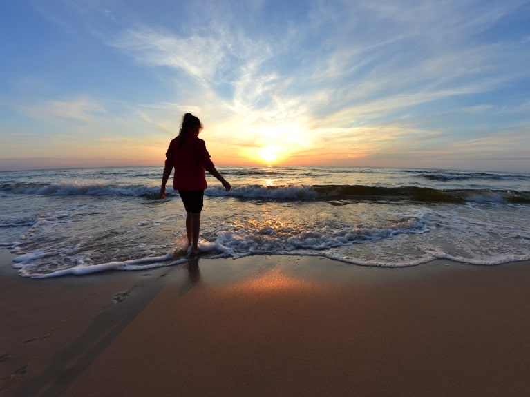 Frau in der Ostsee beim Sonnenuntergang