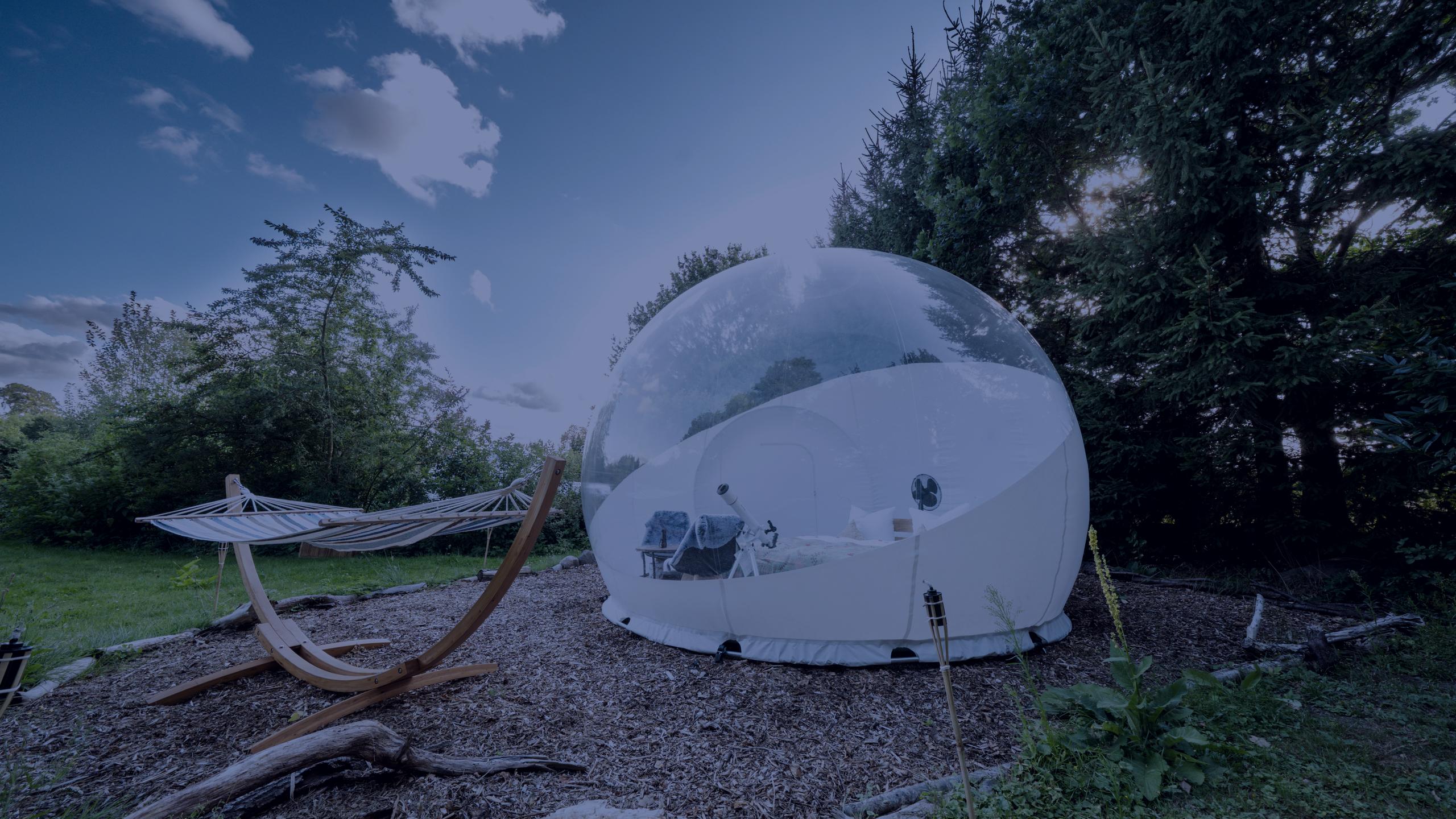 Bubble Tent in der Abenddämmerung, davor eine Hängematte