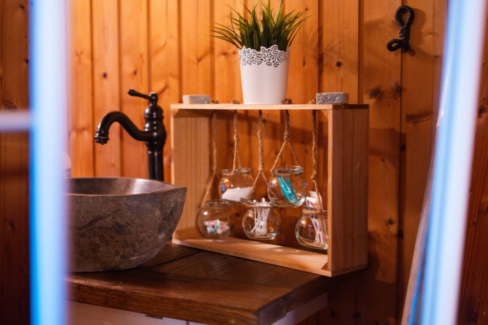 Waschtisch mit Naturstein-Waschbecken im holzverkleideten Sanitärbereich